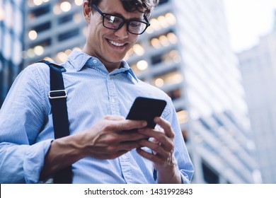 Below view of formally dressed cheerful corporate employee feeling good during online communication in group office chat, successful businessman searching funny content website during work break