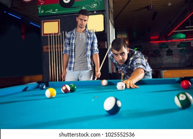 Below View Of Friends Playing Billiard In A Pool Hall