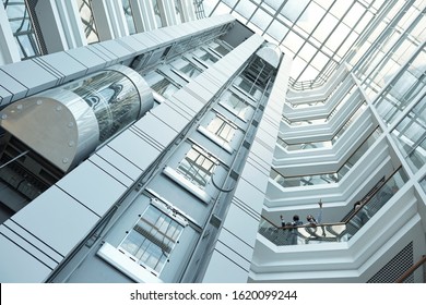 Below view of moving elevator, walls and balconies of contemporary business center that can be used as background - Powered by Shutterstock