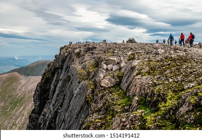 Ben Nevis, UK - August 24 2019: People Hike On The Ben Nevis Summit, In The Scottish Highlands. It Is The Highest Mountain In The British Isles.