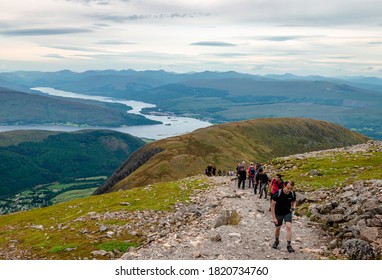 Ben Nevis, UK - August 24 2019: People Hike On Ben Nevis. Fort William (and Some Other Scottish Villages), Loch Linnhe And Loch Eil Are In The Background.