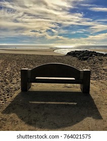 A bench at the beach with an ocean view.
