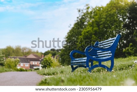 Bench in the local park on Spring fields, Blue Metal stylish Bench in the Park with Green Lawn on Summer Background, Retro vinage tone