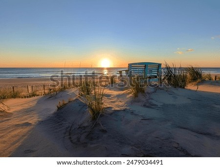 A bench on sandy beach at sunset in Nags Head, North Carolina