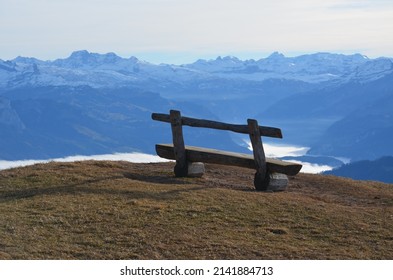 A bench on top of the mountain Rigi in Switzerland overlooking the skyline of mountaintops and lake in Switzerland - Shutterstock ID 2141884713