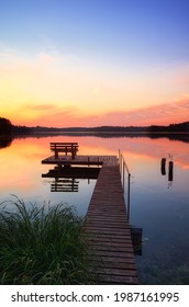 Bench on a wooden pier at sunset, Lipie Lake in Dlugie Village, Poland - Shutterstock ID 1987161995