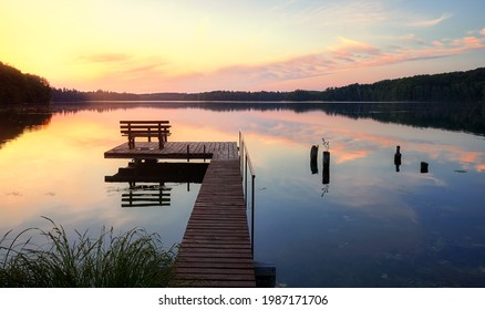 Bench on a wooden pier at sunset, Lipie Lake in Dlugie Village, Poland - Shutterstock ID 1987171706