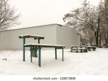 Bench and playground in snow un the yard of the city - Shutterstock ID 528873808