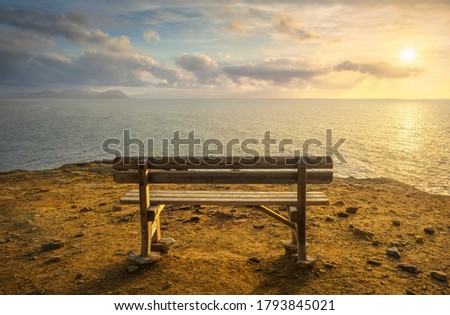 Bench in Populonia famous cliff Buca delle Fate at sunset. Elba Island on the horizon. Piombino, Maremma Tuscany, Italy.