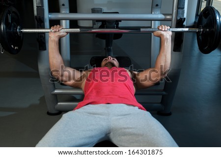 Bench Press At Gym. Young Men In Gym Exercising On The BenchPress