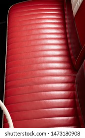 Bench Seat. A Red Leather Bench Front Seat On A Classic Car. An Old Style Drivers Seat. Automobile With A Car Bench-seat