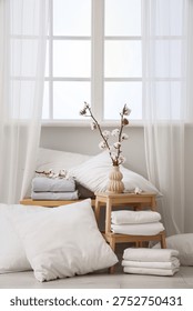 Bench and stool with white bed sheets in light room