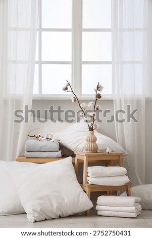 Bench and stool with white bed sheets in light room
