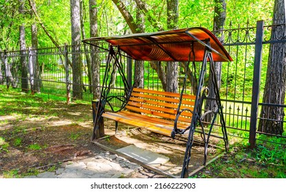 A bench under a canopy in the park in spring.