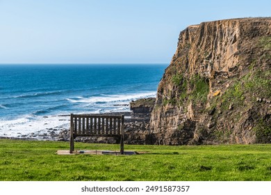 Bench with view of the cliffs on the north Cornish coast near Bude, England, UK