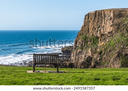 Bench with view of the cliffs on the north Cornish coast near Bude, England, UK