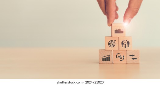 Benchmarking concept. Comparing business processes and performance. Man hold wooden cubes  performance, process, compare and target icon isolated on white background and copy space. Used for banner.