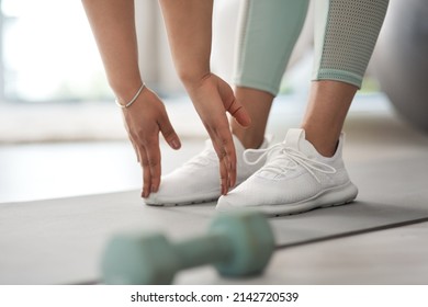 Bend Down And Touch Your Feet. Closeup Shot Of An Unrecognisable Woman Stretching To Touch Her Toes While Exercising At Home.