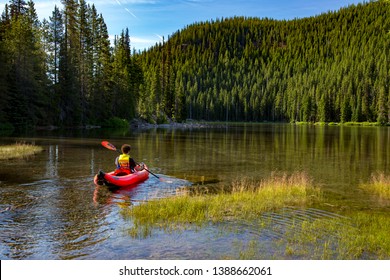 Bend, Oregon - 7/5/2016:  A young man in an inflatable canoe on devil's Lake in the Oregon cascade mountains on century drive near Bend, Oregon
