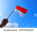 Bendera merah putih. Bendera Indonesia. Bendera negara Indonesia. The Indonesian flag symbolizing independence, on August 17 1945. 17 Agustus 1945. Red and white. Flag background. Hand holding a flag