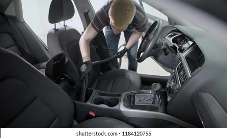 Bending Faceless Worker In Black Rubber Gloves Vacuuming Passenger Seats In Car