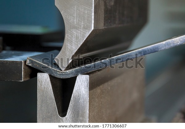 Bending sheet metal with a hydraulic machine at\
the factory. Closeup.