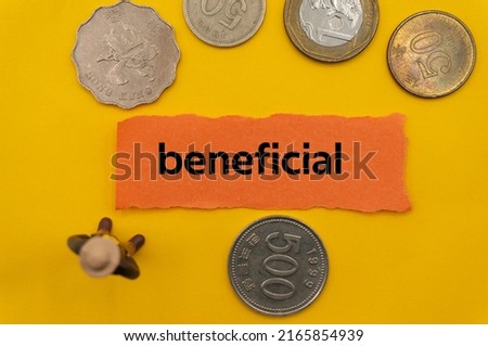 beneficial.The word is written on a slip of paper,on colored background. professional terms of finance, business words, economic phrases. concept of economy.