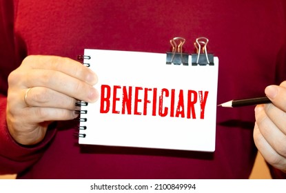 BENEFICIARY word on yellow sheet on table with pen, calculator and graph. Business and finance concept - Shutterstock ID 2100849994