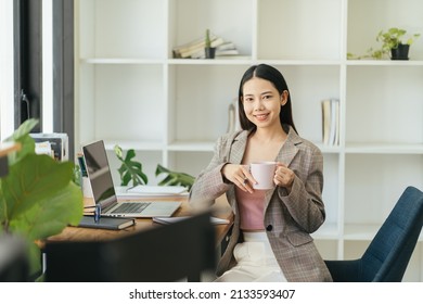 Benefits Of Remote Work. Dreamy Lady Enjoying Coffee During Work On Laptop Computer In City Cafe, Smiling And Looking Aside. Young Freelancer Having Break While Working Online In Internet