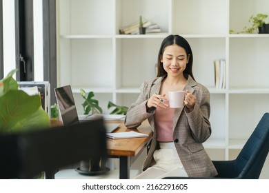 Benefits Of Remote Work. Dreamy Lady Enjoying Coffee During Work On Laptop Computer In City Cafe, Smiling And Looking Aside. Young Freelancer Having Break While Working Online In Internet