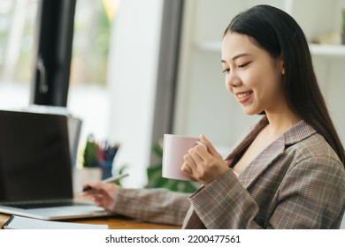 Benefits Of Remote Work. Dreamy Lady Enjoying Coffee During Work On Laptop Computer In City Cafe, Smiling And Looking Aside. Young Freelancer Having Break While Working Online In Internet