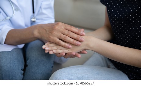 Benevolent female doctor nurse hands holding covering palms of woman patient supporting comforting consoling. Sick young lady receiving empathy compassion of attending physician. Close up cropped view - Shutterstock ID 1878566257