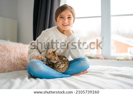 A Bengal cat in the bed room with child girl
