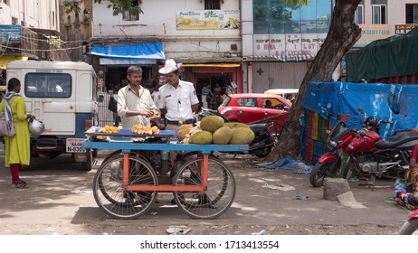 Bengaluru, Karnataka / India - March 15 2020: A Traffic Police Checking The Jackfruits Sold By A Street Hawker Near Russel Market During Daytime