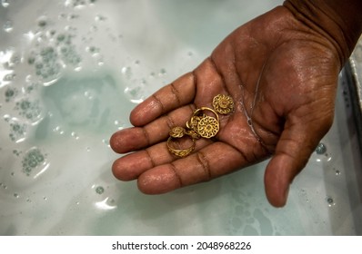 Bengaluru, Karnataka, India- Sep 20 2021: Man Cleaning Gold Jewellery In Chemicals While Cleaning The Gold Jewels Jeweler's Workroom