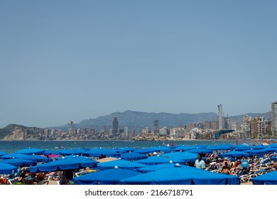 Benidorm, Alicante, Spain 06 12 2022- Benidorm Beach Full Of Blue Umbrellas And Tourists On A Sunny Day.