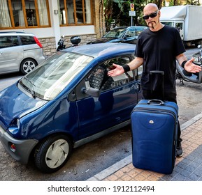 Benidorm Alicante Spain September 22 2019. Man Standing On A Street In Benidorm. Man With Big Blue Suitcase Wondering How To Fit The Bag In A Small Blue Car.