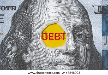 Benjamin Franklin face on USD dollar banknote with punching and debt wording for United States of America have high government debt from economic concept.