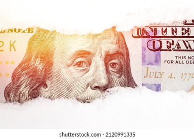 Benjamin Franklin portrait on 100 banknote in torn paper hole with sunlight. Dolar USA close up. Economy, savings and the US dollar