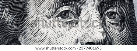 Benjamin Franklin's eyes from a hundred-dollar bill. The eyes of Benjamin Franklin on the hundred dollar banknote, backgrounds, close-up. 100 dollar bill with only eyes of Benjamin Franklin