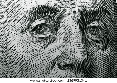Benjamin Franklin's eyes on a hundred dollar bill. Benjamin Franklin portrait. United States national currency banknote fragment