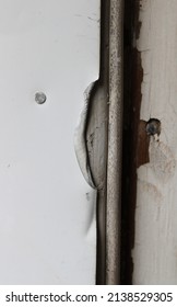 A Bent Edge In The Metal Trim Of A Door Frame 