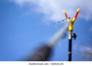 Bent Fishing Rod On The Stand At The Background Of The Sky.