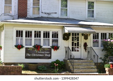 Benton, PA/USA-May 10, 2019:  Charming Storefront Of The Christmas Shop, With Welcoming Christmas Swags On A Sunny Spring Day.