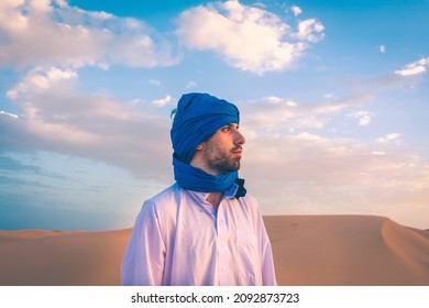 Berber man wearing traditional tuareg clothes in the Sahara Desert at dawn, Merzouga, Morocco