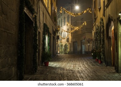 BERGAMO, ITALY - 12 JANUARY 2016: Old European narrow empty street of medieval town with Christmas decoration on a foggy evening. Taken in Bergamo, Citta Alta, Lombardia, Italy.