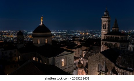 Bergamo, Italy. The old town. Amazing aerial view of the Basilica of Santa Maria Maggiore and the dome of the cathedral in the night. In the background the Po plain. Bergamo best of Italy