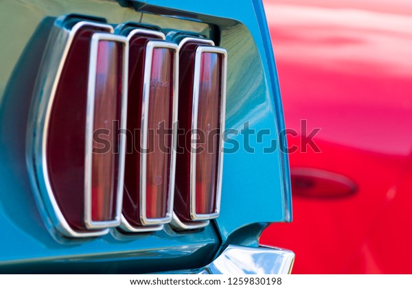 BERGEN, NORWAY - 4/29/18: Close\
up  detail side view of the tail lights and shiny chrome bumper of\
a 1969 Ford Mustang, parked outside during an amcar owners\
meeting.