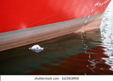 Bergen, Norway - January 18 2020:  A Plastic Shopping Bag From REMA 1000 Supermarket Is Floating Next To The Hull Of An Industrial Tug Boat In Bergen Harbor.