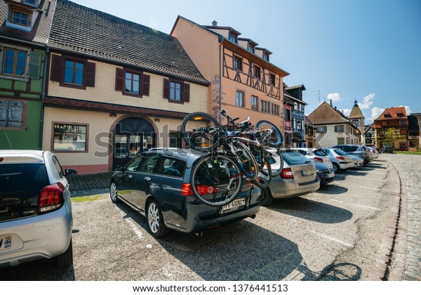 Bergheim, France - 19 Apr 2019: Tourist car with\
multiple Bikes on the trailer parked in front of the city-hall main\
place 